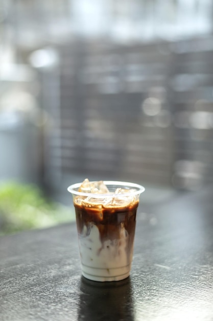 café glacé dans du verre en plastique sur une table noire au café