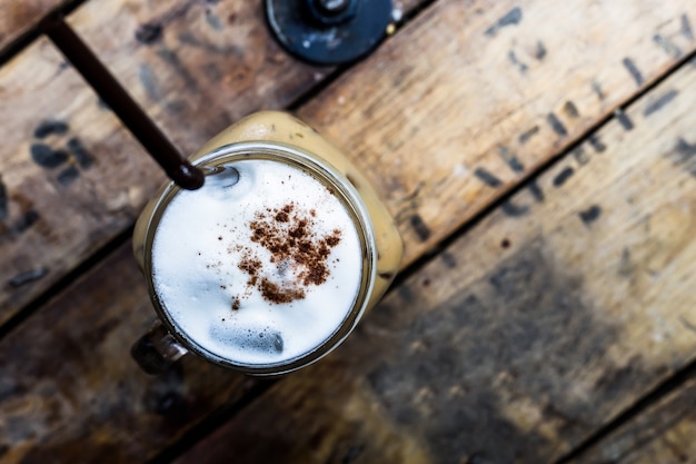 Café glacé avec du lait sur fond en bois