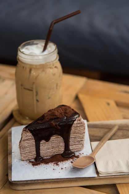 café glacé frais et délicieux gâteau au crêpe au chocolat servir sur un plateau en bois dans un café