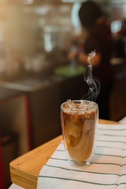 Café glacé sur table avec de la crème versée dedans montrant la texture