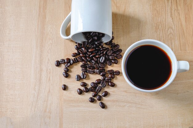 Café et grains de café dans une tasse de café sur une table en bois