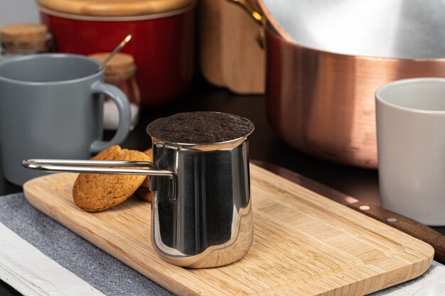 Café infusé dans un turk en métal sur un comptoir de cuisine close up