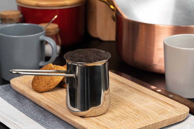 Café infusé dans un turk en métal sur un comptoir de cuisine close up