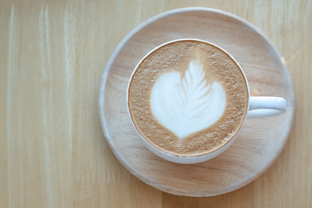 Café Latte art et grains de café torréfiés au matin avec le soleil sur