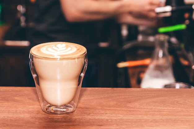 Café latte art sur une table en bois dans un café