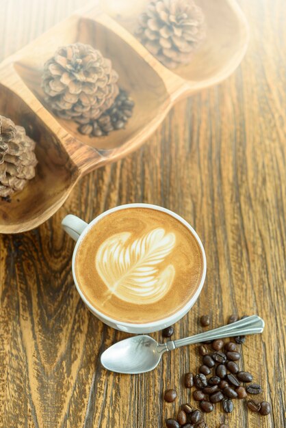 Café latte art sur table en bois.