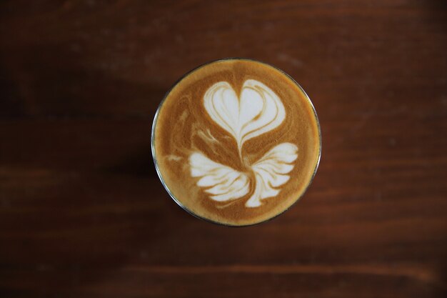 Photo café latte chaud sur fond de bois