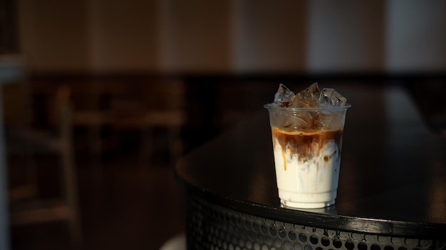 Café Latte glacé dans un verre en plastique sur une table noire dans un café