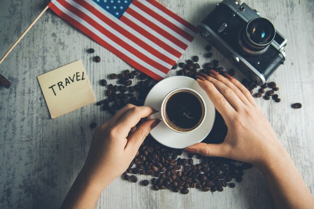 Café main femme avec concept de voyage sur table