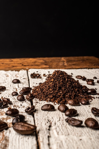 Café moulu et grains de café sur fond de bois blanc