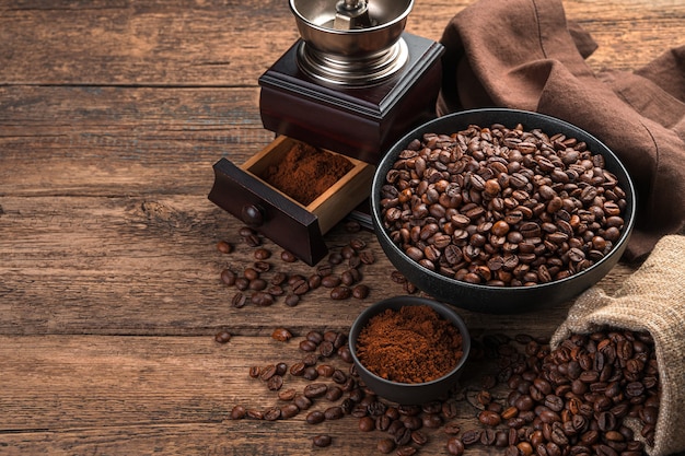 Café moulu en grains et un moulin à café sur un mur marron