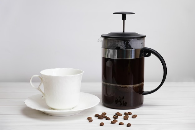 Café moulu pressé à la française et tasse et soucoupe en porcelaine blanche