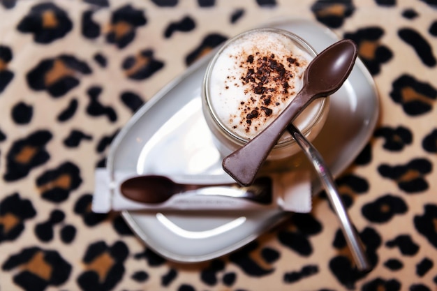 Café à la mousse de lait avec une cuillère en chocolat