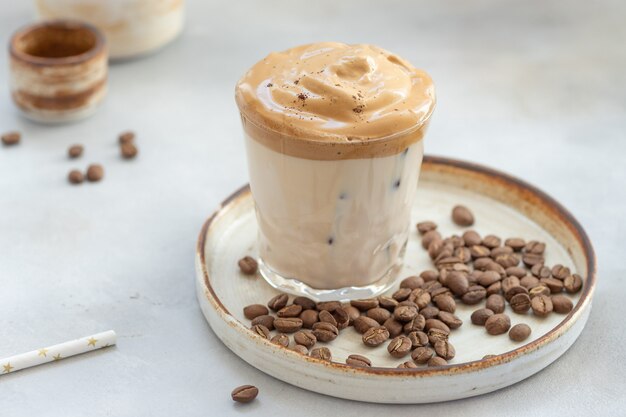 Café avec mousse sucrée et glace dans un verre