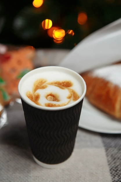 Café de Noël et croissants avec des cadeaux et des jouets sur le fond de l'arbre de Noël