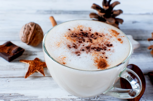 Café de Noël avec du lait, des épices ou du cacao chaud, des pommes de pin