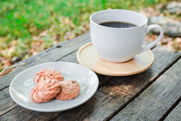 Café noir et cookie sur la table en bois