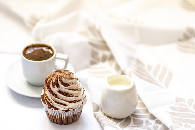 Café noir avec cupcakes et muffins Cupcakes aux épices avec glaçage au fromage à la crème décoré d'un cacao