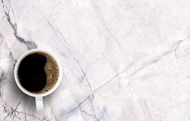 Café noir dans une tasse blanche sur fond de marbre blanc