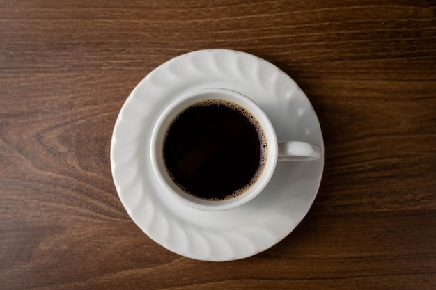 Café noir dans une tasse blanche sur une table en boisxDxA