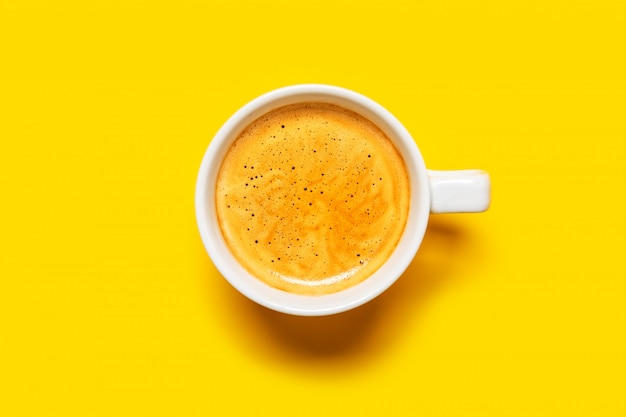 Café noir dans une tasse sur un jaune