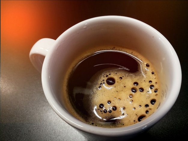 Café noir dans une tasse se bouchent sur la table