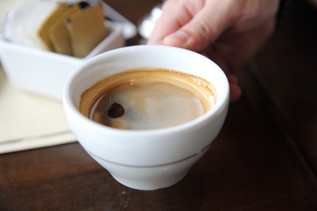 Café noir sur fond de bois dans un café