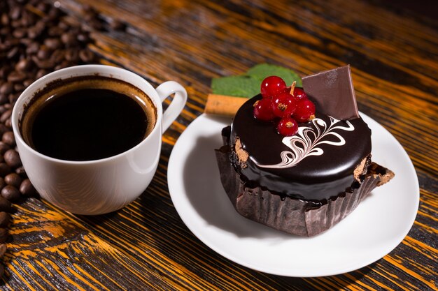 Café noir frais dans une tasse par cupcake au chocolat