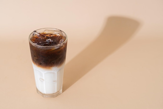 Café noir glacé avec couche de lait en verre