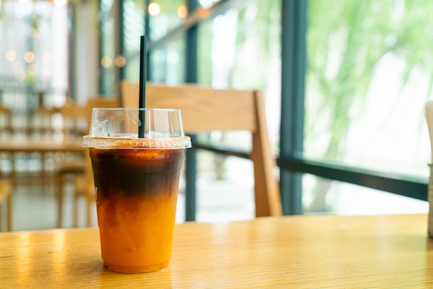 café noir glacé avec une tasse de jus de yuzu orange sur une table dans un café café