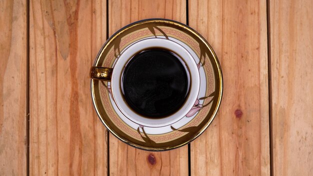 Café noir à la tasse sur la table en bois supérieure