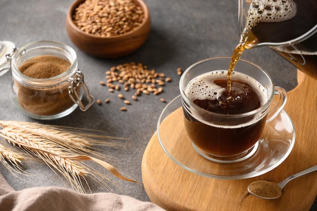 Café d'orge dans une tasse blanche et épis d'orge sur fond gris