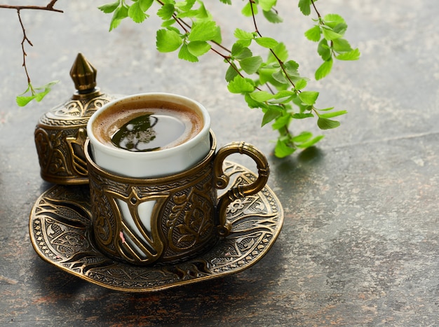 Café oriental cuit dans un pot de café turc traditionnel en cuivre versé dans une tasse