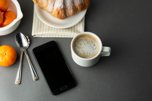 Café de petit déjeuner avec croissant, agrumes français, pâtisserie, tasse de café ou café au lait. La caféine est une drogue.