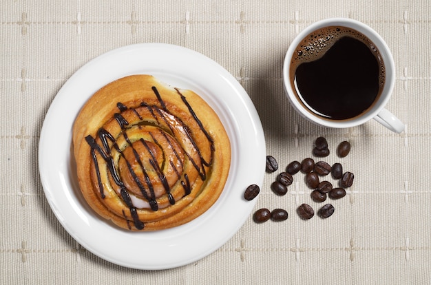 Café et petit pain sur la table en bois