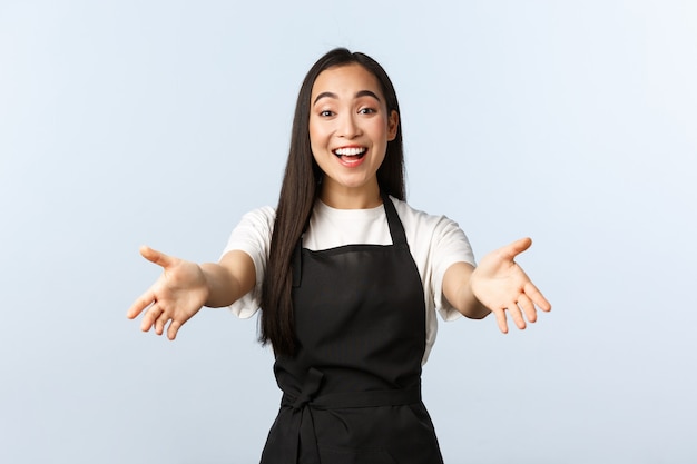 Café, petite entreprise et concept de démarrage. Le personnel souriant et amical du café invite à entrer et à savourer une tasse de cappuccino, à tendre les mains vers l'avant, à accueillir les clients, à servir des boissons au comptoir du bar