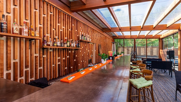 Café en plein air vide d'été au parc. Bar au design moderne, murs en bois, tabourets hauts