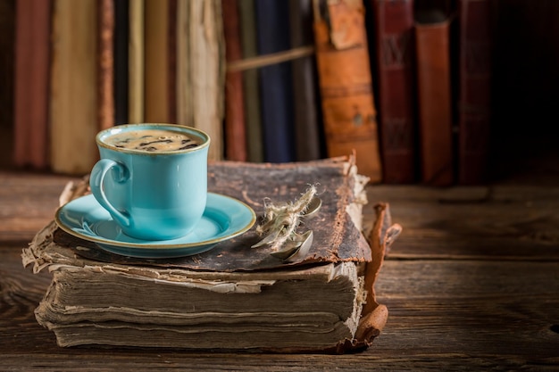 Café en porcelaine bleue dans la bibliothèque sur un vieux livre