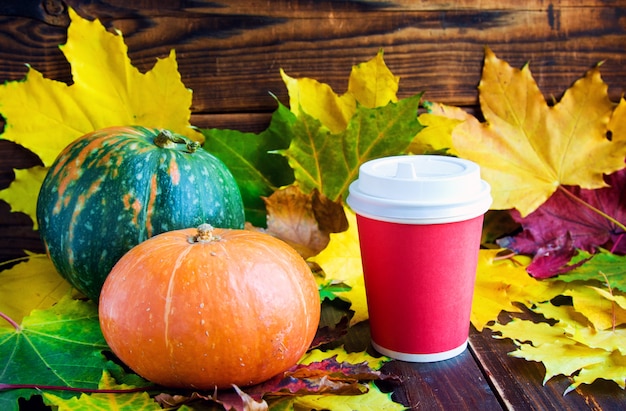 Café rouge pour aller tasse avec feuille de marple et citrouilles