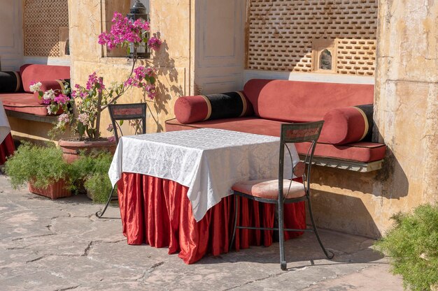 Café de la rue dans la vieille ville, à l'extérieur de Jaipur, Rajasthan, Inde. Table, canapé et chaises près du vieux mur, gros plan