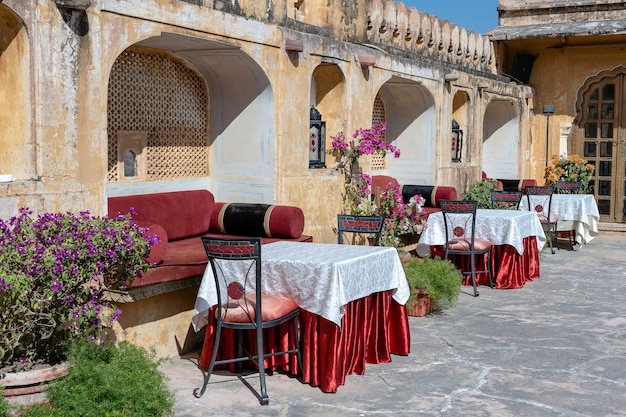 Café de la rue dans la vieille ville, à l'extérieur de Jaipur, Rajasthan, Inde. Table, canapé et chaises près du vieux mur