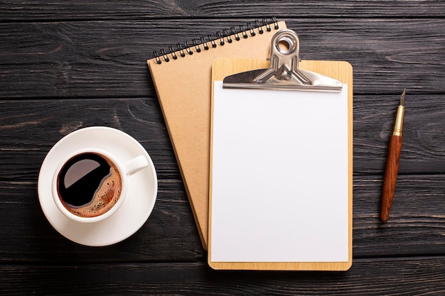 Café avec une tablette pour écrire sur un fond en bois foncé