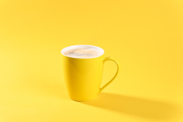 Photo café en tasse jaune sur fond jaune