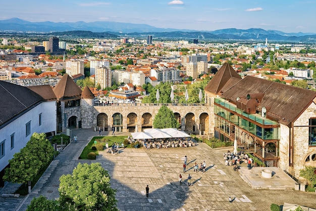 Café-terrasse avec des gens dans la cour du vieux château sur la colline du château dans le centre historique de Ljubljana, Slovénie