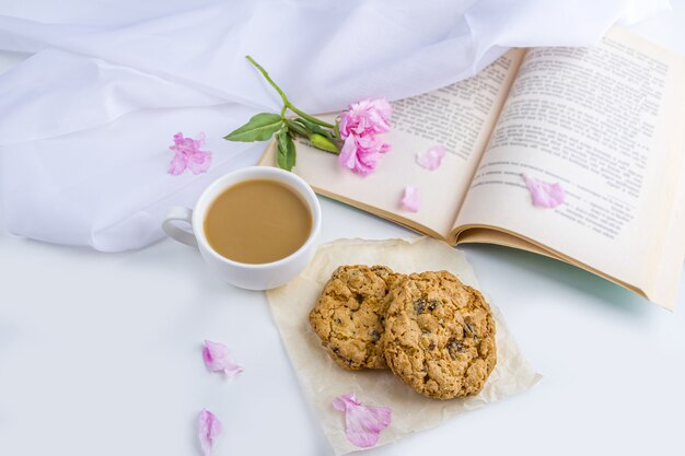 Café ou thé avec biscuits au lait et à l'avoine. Lecture de vieux livre et collation au printemps, journée d'été dans le jardin