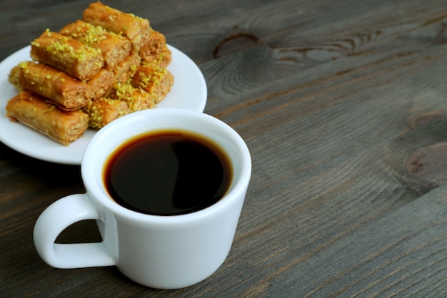 Café turc sur table en bois avec des pistaches pâtisseries Baklava