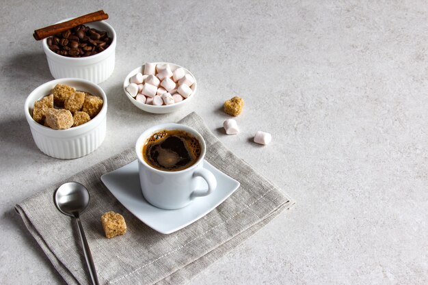 Café à la vanille avec cassonade et guimauve Savoureux expresso à la vapeur dans une tasse avec des grains de café