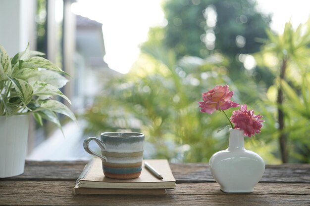 Café et vase de rose sur une table en bois