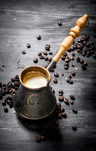 Cafetière fraîche avec des grains autour.