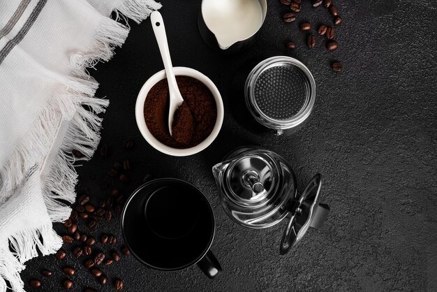 Cafetière Geyser, café moulu et une tasse sur fond noir. Composition du café. Préparation du café. Photo de haute qualité